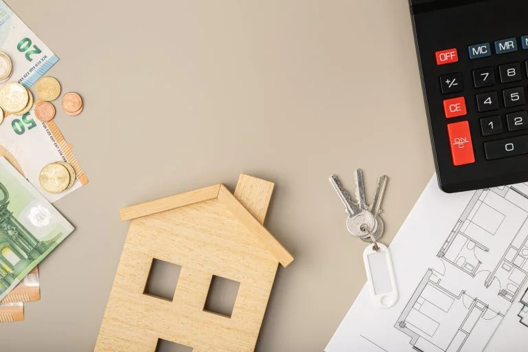 Divers objets mis en scène pour illustrer l'achat ou la vente d'un projet immobilier.